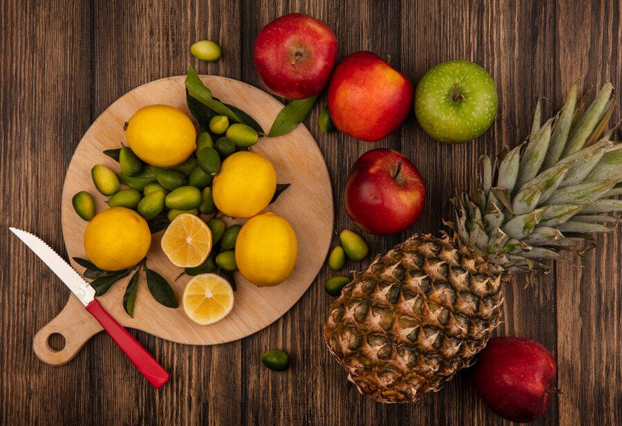 top-view-of-fresh-lemons-isolated-on-a-wooden-kitchen-board-with-apples-and-pineapples-isolated-on-a-wooden-surface_141793-81133.jpg
